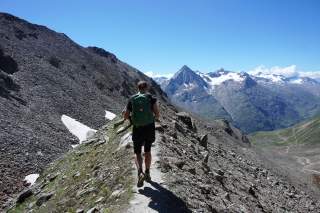 Wanderin läuft auf Steig durch die Berge