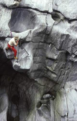 Jürgen Winkler, ein bekannter Bergfotograf, fotgrafiert angeseilt in der Felswand.