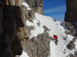 Person beim Winterbergsteigen an schneebedecktem Hang.