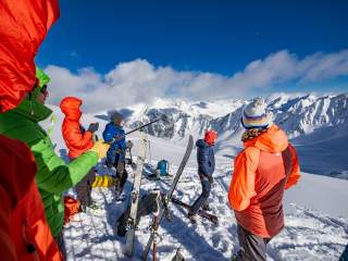Der Expedkader ist von hinten zu sehen und blickt ins Bergpanorama im Hintergrund