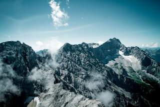 Graue schroffe Gipfel vor blauem Himmel.