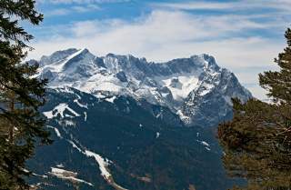 Blick auf das Wettersteingebirge mit Zugspitze und Alpspitze: während die Gipfel verschneit sind, ist das Tal ausgearpert.