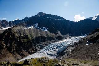 Eine raue Hochgebirgslandschaft, in der Mitte ein Gletscher.