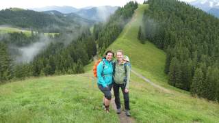 Zwei Frauen auf einer Voralpen-Wanderung am Hörnle. Es ist neblig, die Wiesen sind saftig-grün.