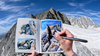 Person malt Aquarellskizze einer Berglandschaft in einem Skizzenbuch vor einer realen Bergkulisse mit blauem Himmel.