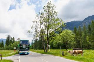 Bergbus fährt durch Voralpenlandschaft