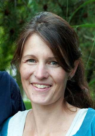 Frau vor grüner Hecke