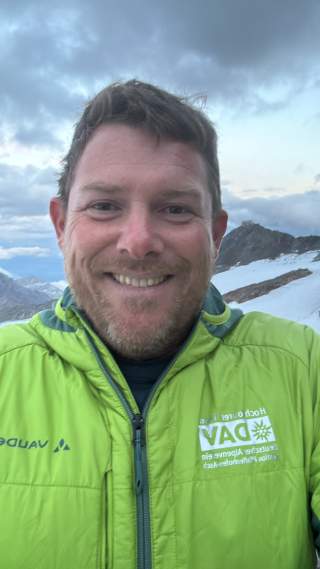 Mann in grüner Jacke in den Bergen