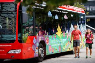 Zwei Wandernde neben Bergbus