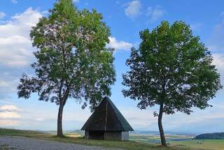 Hütte auf Anhöhe zwischen zwei Bäumen