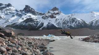 Person zieht sich an einer gespannten Leine über einen Fluss.