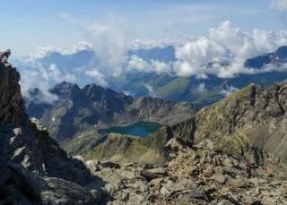 Ausblick über Berge mit Bergsee und Wolken