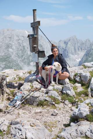 Frau mit Hund an Gipfelkreuz