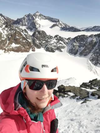 Selfie einer Frau mit Helm und Sonnenbrille in den Bergen