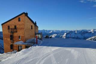 Das Neue Hannoverhaus im Winter. Eine holzverschindelte Alpenvereinshütte, direkt an der Skipiste.
