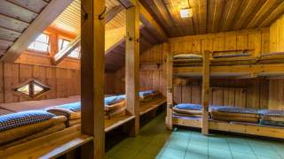 Ein sogenanntes Bettenlager - ein großer Schlafraum auf einer Alpenvereinshütte mit mehreren Doppelstock- und Einzelbetten.