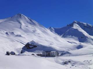 Die Heidelberger Hütte, umgeben von tief verschneiten, hohen Berggipfeln.