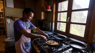 Mann bereitet Kaiserschmarrn in Hüttenküche zu