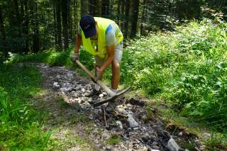 Mann mit Warnweste beim Wegebau