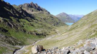 Blick in Tal mit Bachbett in den Bergen