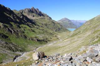 Blick in Tal mit Bachbett in den Bergen