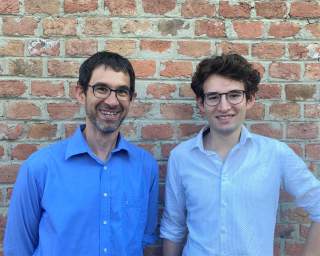 Vater und Sohn stehen vor Ziegelwand