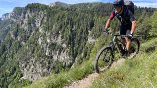 Mountainbiker auf schmalem Trail mit schöner Aussicht