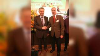 Josef Klenner und Ludwig Wucherpfennig bei der Hauptversammlung in Osnabrück. Zwei Männer in Anzügen schütteln Hände und lächeln in die Kamera.