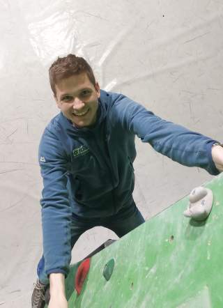 lächelnder Mann an Kletterwand