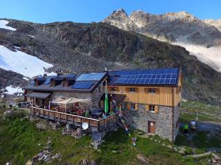 Berghütte mit Solarmodulen auf dem Dach