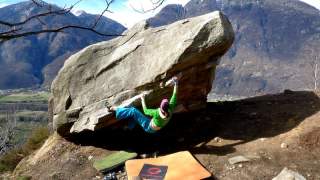 Frau bouldert an Felsen