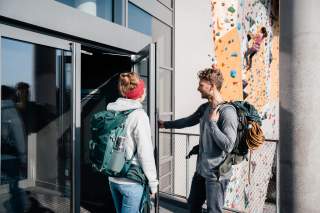 Kletterer betreten die Kletterhalle