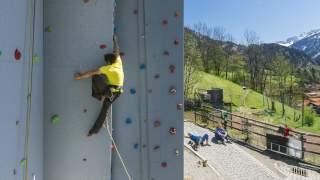 Person klettert an Outdoor-Kletterwand