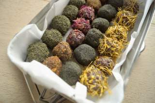 Hier sind die im Rezept beschriebenen Energie-Kugeln mit den verschiedensten Ummantelungen in bunten Farben zu sehen.