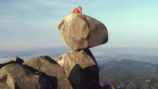 Aufnahme eines biwakierenden Bergsteigers auf dem Berg "Uomo di Cagna". Der Uomo di Cagna ist ein markanter, weitherum sichtbarer Berg mit einem Wackelfelsen obenauf auf der Insel Korsika. Dieser scheint jeden Moment ins Tal rollen zu wollen.
