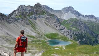 Bergsteiger über dem Hintersee mit Blick auf Stanskogel und Fallesinspitze.