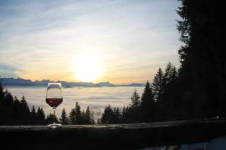 Glas Rotwein auf Hüttenbalkon mit Aussicht