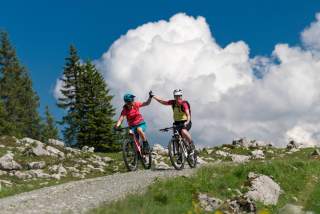 Zwei Frauen auf Mountainbikes schlagen ein