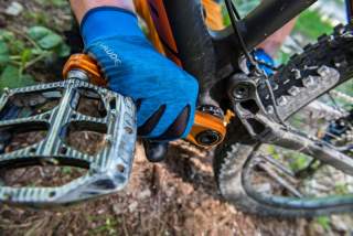 Hand greift an Pedale eines Mountainbikes