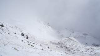 Man sieht kaum, so dicht ist der Nebel. Aber die Wiesen tragen frischen Schnee.