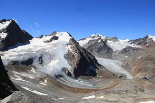 Naturnahe Hochgebirgslandschaft mit großen Gletscherzungen, Schuttflächen und eisbedeckten Gipfeln
