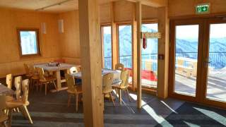 Eine moderne, lichtdurchflutete Stube auf einer Berghütte.