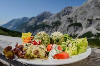 Spinatknödel mit Salat auf Holztisch