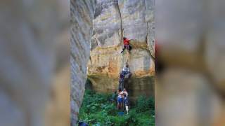 Kletterer bauen menschliche Pyramide am Kletterfelsen