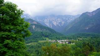 Blick auf den Talboden des Val Resia mit dichtem Wald, dem Weiler Lischiazze und der Bergkette des Monte Musi.