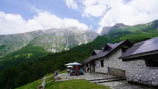 Almgebäude der Malga Coot im Val Resia mit Ausläufern des Monte Canin.