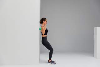 Frau macht Faszientraining an der Wand Frau macht Faszientraining an der Wand