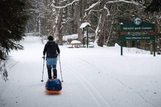 Skiläufer passiert den Eingang zum Nationalpark Sumava