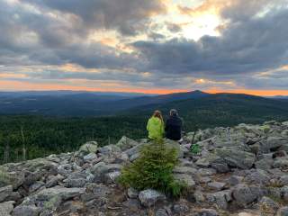 Zwei Menschen auf dem Lusengipfel mit Blick auf den Nationalpark Bayerischer Wald