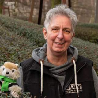 Frau vor grüner Hecke